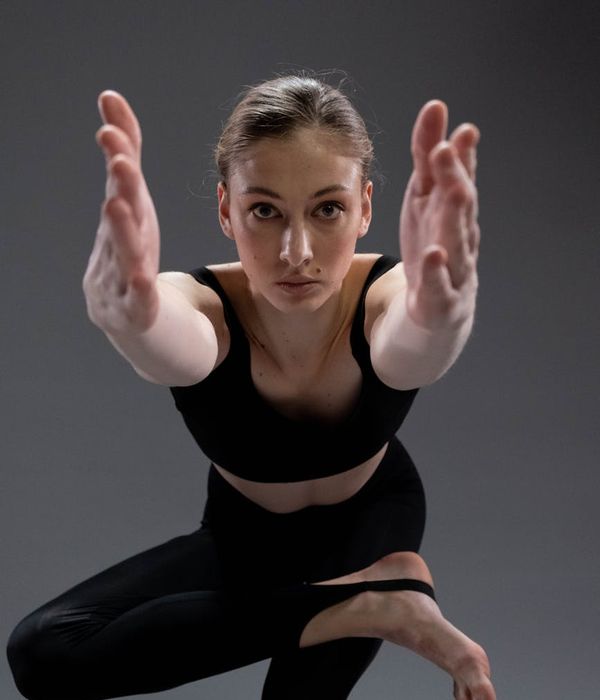 Woman practicing yoga pose in a peaceful dark studio